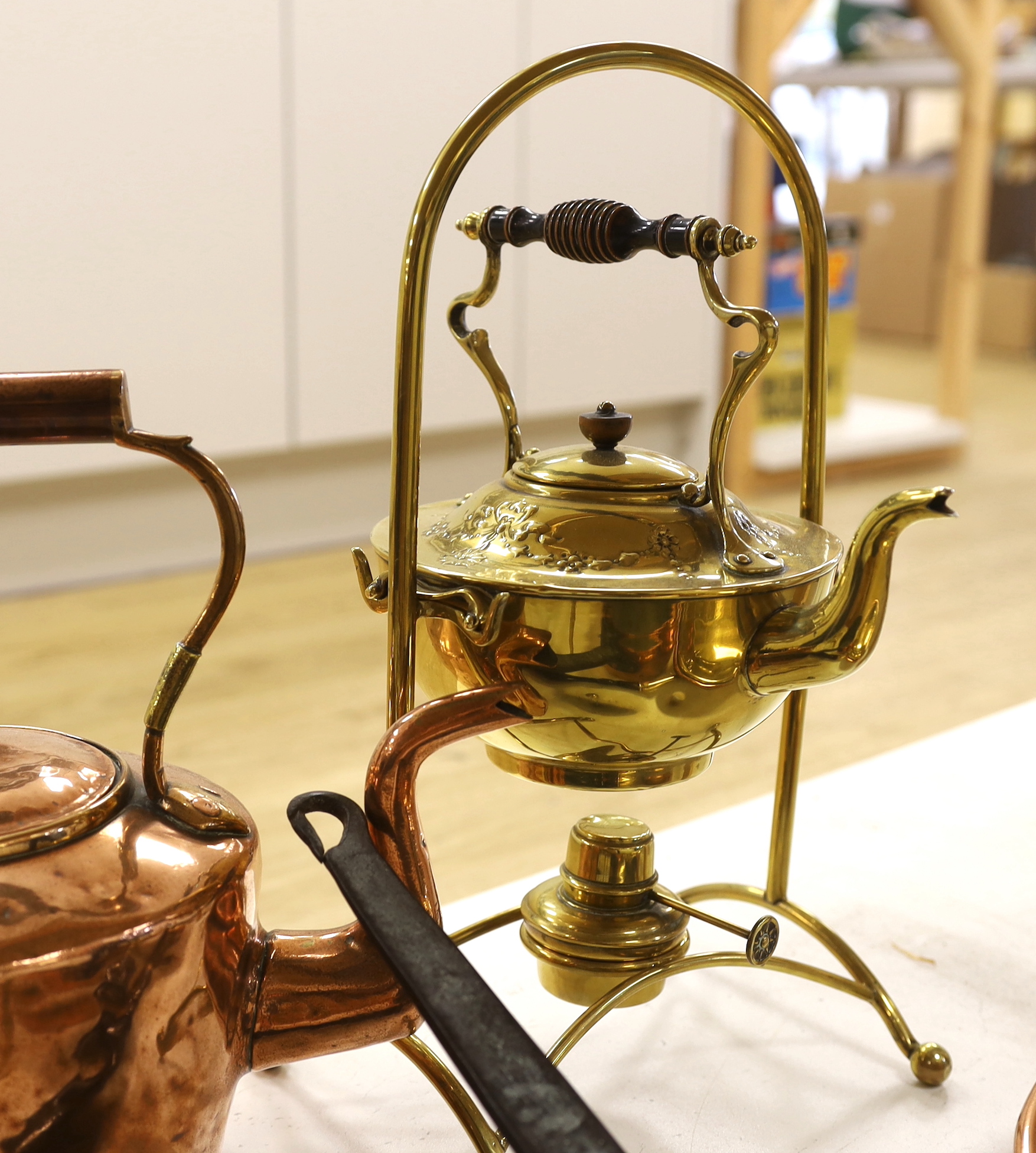 A mixed group of brass / copper wares: copper kettle, a brass spirit kettle, a copper saucepan, a brass trivet and a brass and copper warming pan with ebonies handle, the largest 104cm in length